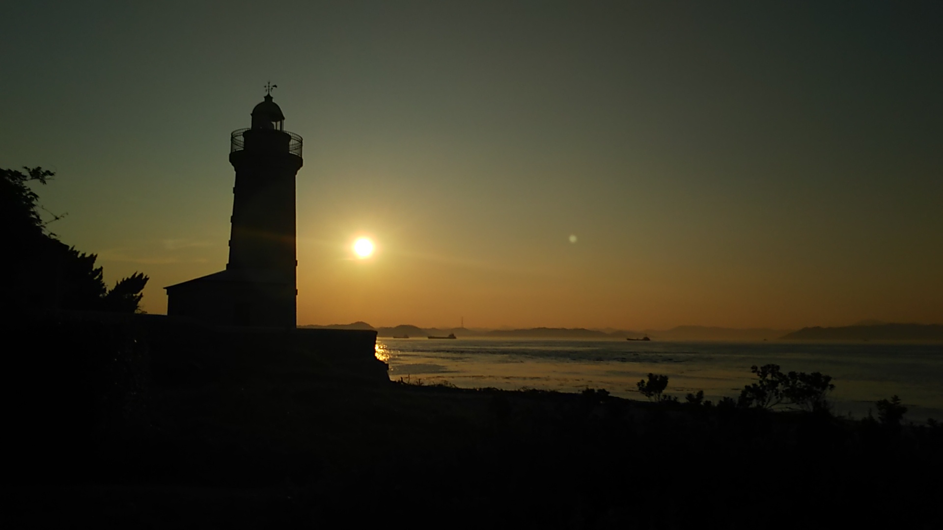 夕暮れに泥む男木島灯台と夕日